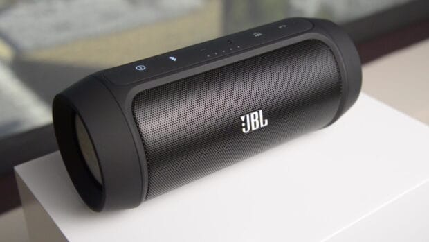 The black portable JBL speaker shows control buttons on top placed on a white surface, HD Desktop Wallpaper