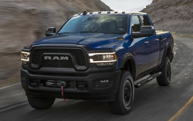 A blue Ram truck driving fast on a winding mountain road in the daytime, HD Desktop Wallpaper