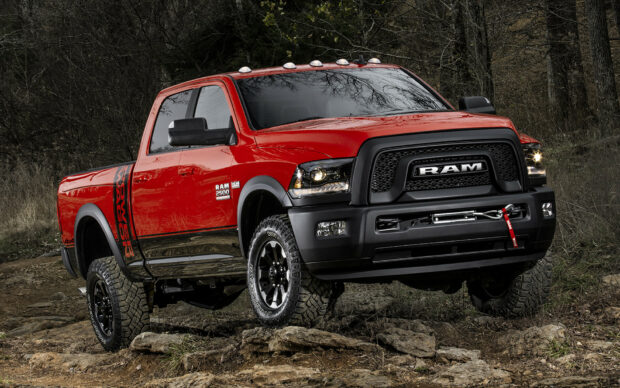 A red Ram truck is parked on a rocky off road trail surrounded by trees and dry grass, HD Desktop Wallpaper