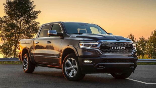 A Ram pickup truck is parked on the road with tall trees and a glowing sunset in the background, HD Desktop Wallpaper