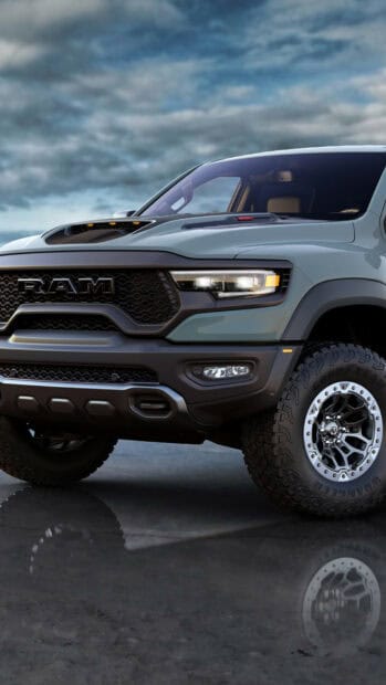 A powerful Ram truck showcases its front grille and headlights under a cloudy sky, HD Mobile Wallpaper