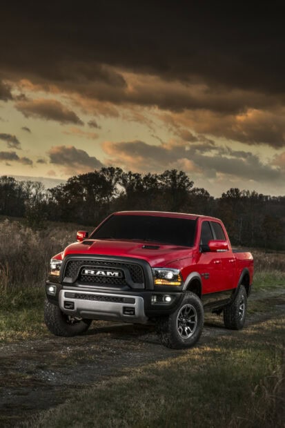 A red Ram truck is parked on a dirt road with autumn trees and a dramatic sunset sky, HD Phone Wallpaper