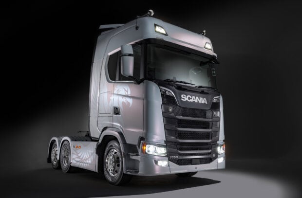 A silver Scania truck with illuminated headlights stands out against a dark background, HD Desktop Wallpaper