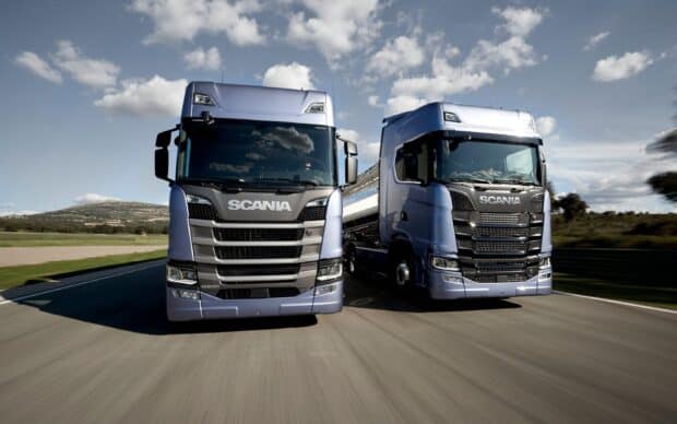 Two modern Scania trucks drive side by side down a highway on a clear day, 2K Desktop Wallpaper