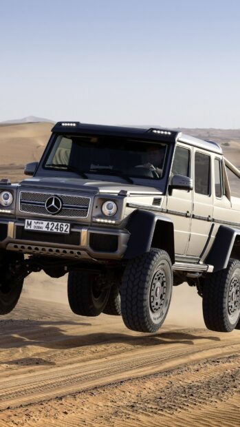 A Mercedes SUV is jumping over sand dunes during off road driving, HD Mobile Wallpaper