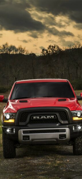 A red Ram truck is parked on a dirt road with trees and a cloudy sky in the background, HD Phone Wallpaper