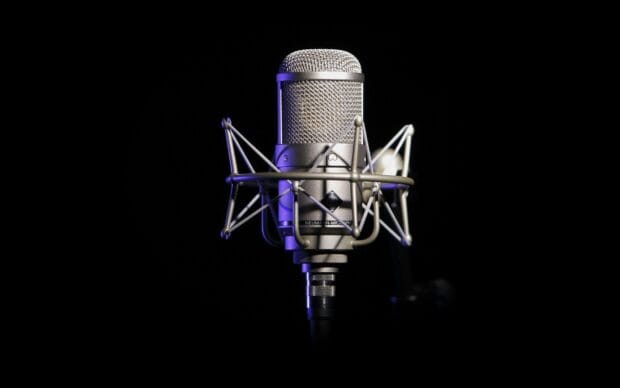 A professional microphone with metal mesh is shown in clear detail against a black background, HD Desktop Wallpaper