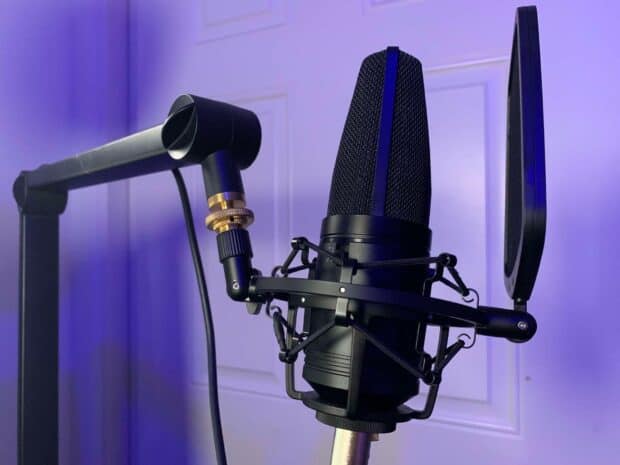A black professional microphone setup ready for studio recording in a purple lit room, HD Desktop Wallpaper