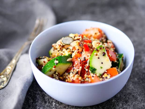 A bowl of quinoa salad with tomatoes and zucchini served on a table, HD Desktop Wallpaper
