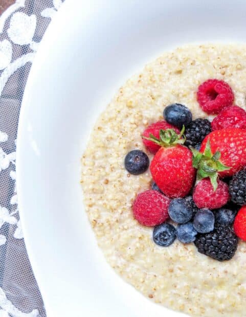 A bowl of quinoa topped with fresh strawberries, raspberries, blueberries, and blackberries, 2K Mobile Wallpaper