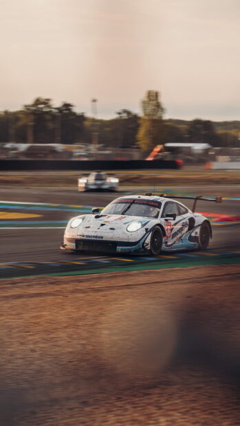 A Porsche race car speeds along a race track during sunset, HD Phone Wallpaper