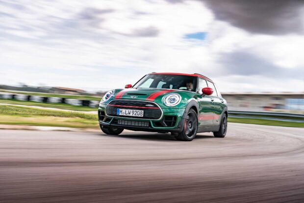 A green race car is taking a sharp turn on a race track under a cloudy sky, HD Desktop Wallpaper