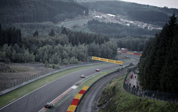 Cars are racing on a winding race track surrounded by trees, HD Desktop Wallpaper