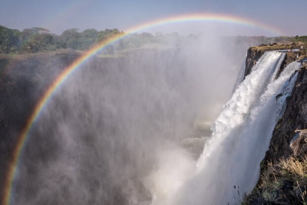 A vibrant rainbow appears over Devils Pool at Victoria Falls in Zambia, HD Desktop Wallpaper