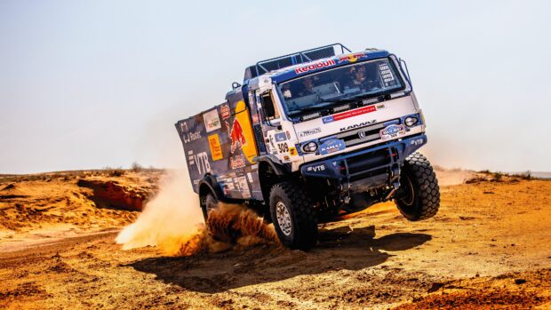 A rally raid truck speeds through the desert kicking up dust trails, 4K Desktop Wallpaper