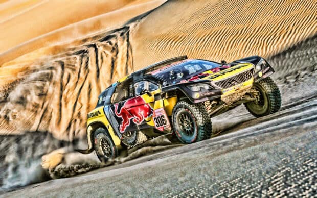 A rally raid race car is seen kicking up sand as it speeds across the dunes, 2K Desktop Wallpaper