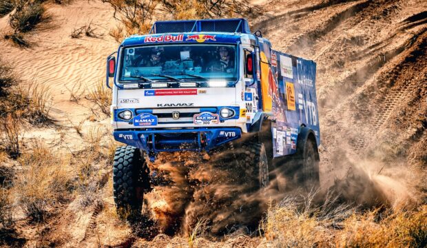 A rally raid truck kicks up dust while racing across a sandy desert, HD Desktop Wallpaper