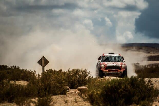 A rally raid vehicle kicks up dust as it speeds across sandy terrain during a race, HD Desktop Wallpaper