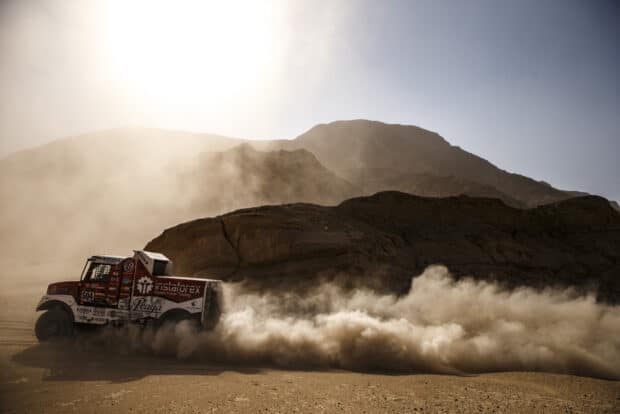 A rally raid truck moves fast kicking up a large cloud of dust in a desert landscape with hills, HD Desktop Wallpaper
