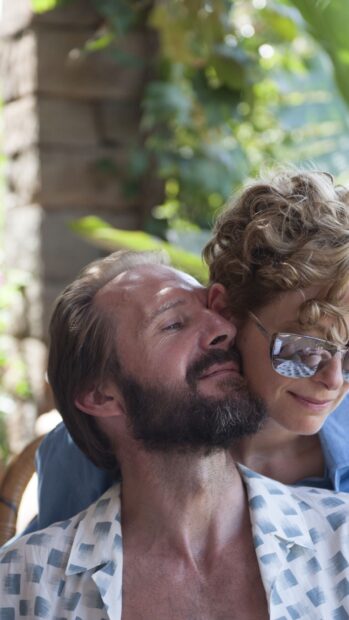Ralph Fiennes shares a tender moment with a woman in a sunny setting, HD Phone Wallpaper