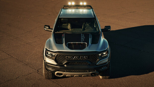 A Ram Truck is parked on cracked asphalt under sunlight showing its front design, 4K Desktop Wallpaper