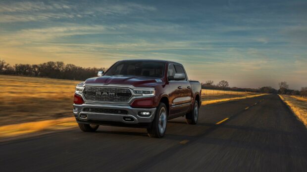 A Ram pickup drives down an empty country road during sunset, 2K Desktop Wallpaper