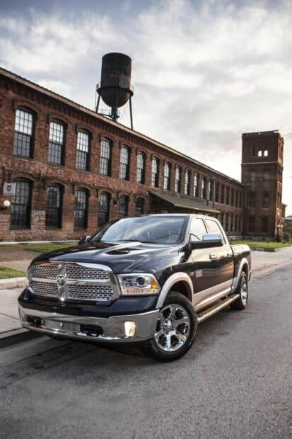 Ram pickup truck is parked on a city street beside a historic brick building and water tower, HD Phone Wallpaper