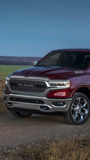 A red Ram pickup stands on a dirt road with fields and hills in the background, HD Mobile Wallpaper