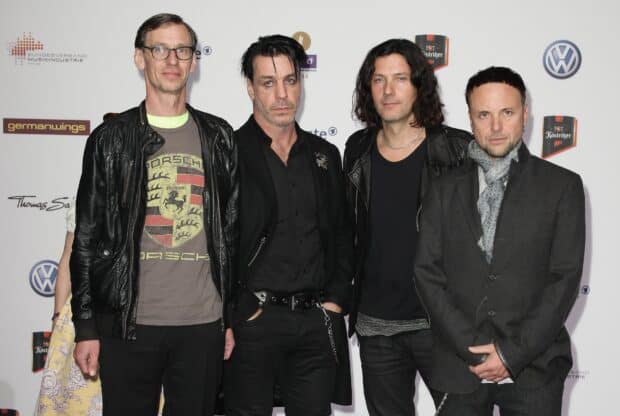 The Rammstein band members stand in front of a white backdrop with logos at an event, HD Desktop Wallpaper