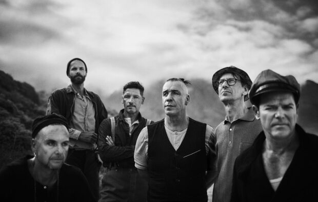 A black and white portrait of Rammstein band members standing outdoors with mountains in the background, HD Desktop Wallpaper