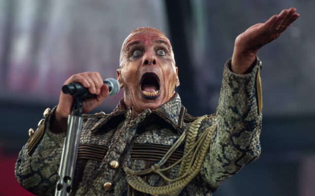The Rammstein lead singer is passionately performing on stage with an intense facial expression, 2K Desktop Wallpaper
