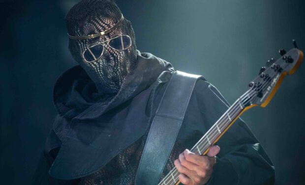 A musician wearing a mask plays bass guitar during a live Rammstein performance, 2K Desktop Wallpaper