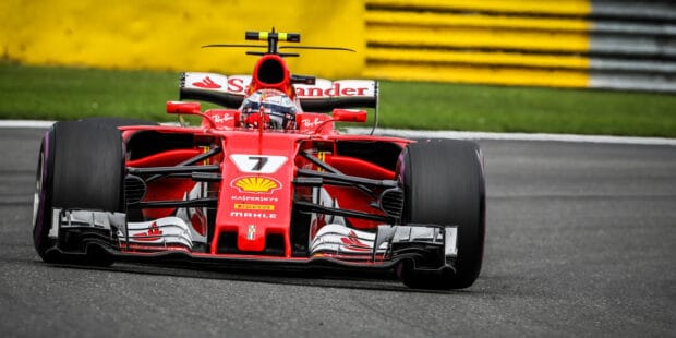 A red F1 race car is taking a sharp turn on the race track during the competition, 2K Desktop Wallpaper