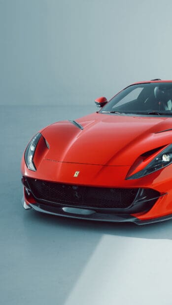 A red Ferrari 812 Gts is shown from the front with detailed headlights and spoiler, 4K Phone Wallpaper