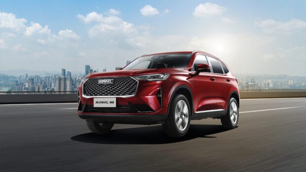 A red Haval SUV drives on a highway with a city skyline in the background featuring Great Wall Motors, HD Desktop Wallpaper