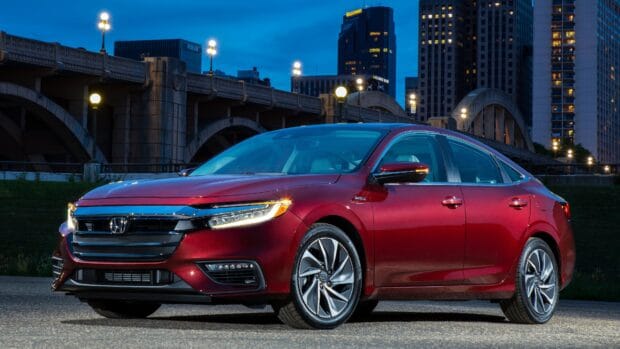 The red Honda Insight is parked under a city bridge with lights glowing at night, 4K Desktop Wallpaper