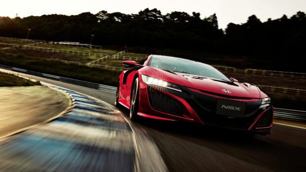A red Honda NSX is captured speeding on a curved race track during sunset, 4K Desktop Wallpaper