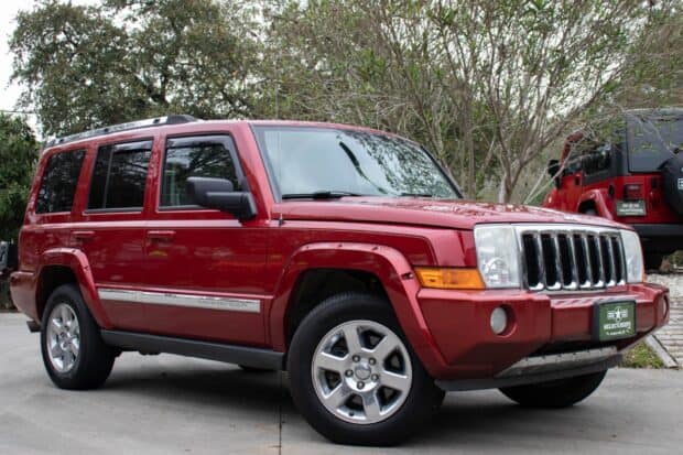 A red Jeep Commander parked outdoors near trees on a cloudy day, HD Desktop Wallpaper