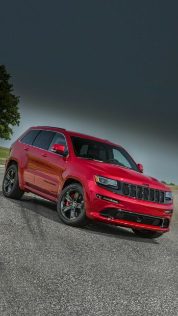 A red Jeep Grand Cherokee is parked on an asphalt road under a clear sky, HD Phone Wallpaper