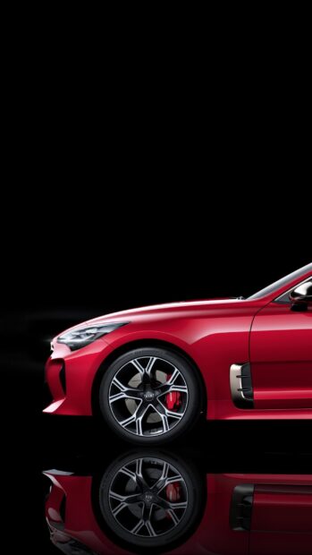 A red Kia Stinger is captured with intricate wheel details and glossy finish reflecting below, 2K Phone Wallpaper