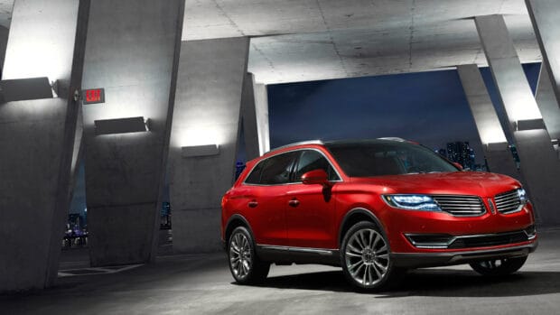 A red Lincoln car is parked under a concrete structure at night in the city, 4K Desktop Wallpaper