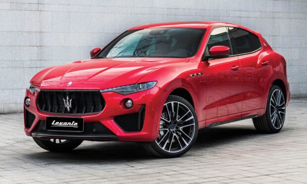 A red Maserati Levante stands parked on a tiled street near a gray wall, HD Desktop Wallpaper
