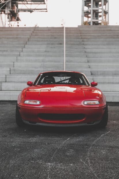 A red Mazda MX 5 Miata car is parked in front of concrete stairs, HD Phone Wallpaper