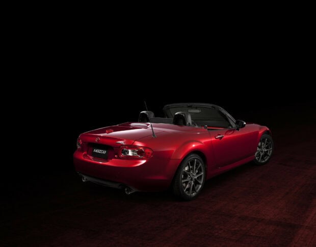 A red Mazda MX 5 Miata convertible is shown from the rear against a dark background, HD Desktop Wallpaper