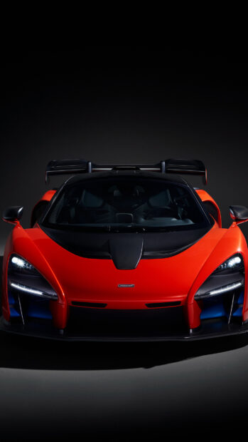The red McLaren Senna shows its striking front design with headlights on in a dark setting, 2K Phone Wallpaper
