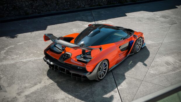 Red McLaren Senna parked outdoors with visible aerodynamic design and rear wing, 4K Desktop Wallpaper