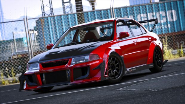 A red Mitsubishi Lancer Evo sports car parked near a chain link fence with sponsor logos, 2K Desktop Wallpaper