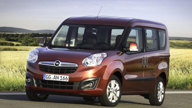 A red Opel Combo is parked on a rural road near green fields under a clear sky, HD Desktop Wallpaper