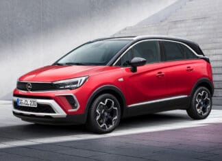A red Opel Crossland is parked on a tiled surface near concrete stairs under natural light, 4K Desktop Wallpaper