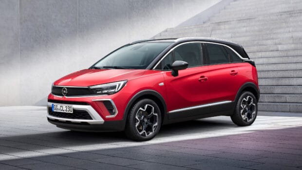 A red Opel Crossland is parked on a tiled surface near concrete stairs under natural light, 4K Desktop Wallpaper